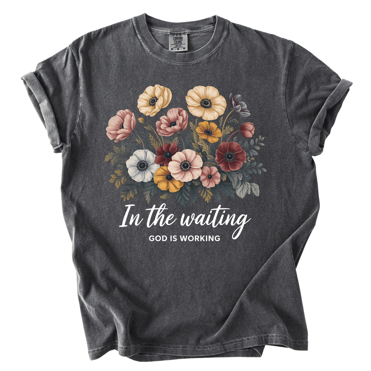A gray t-shirt with a floral design and the text "In the waiting, God is working" printed on it.