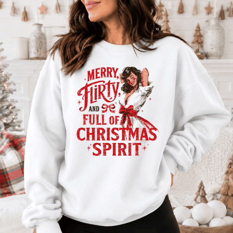 A woman wearing a white sweatshirt with a Christmas-themed design and text printed on it.