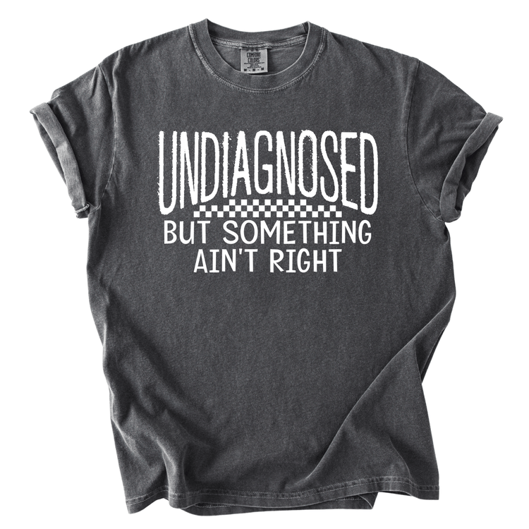 A gray t-shirt with white text that reads "UNDIAGNOSED BUT SOMETHING AIN'T RIGHT".