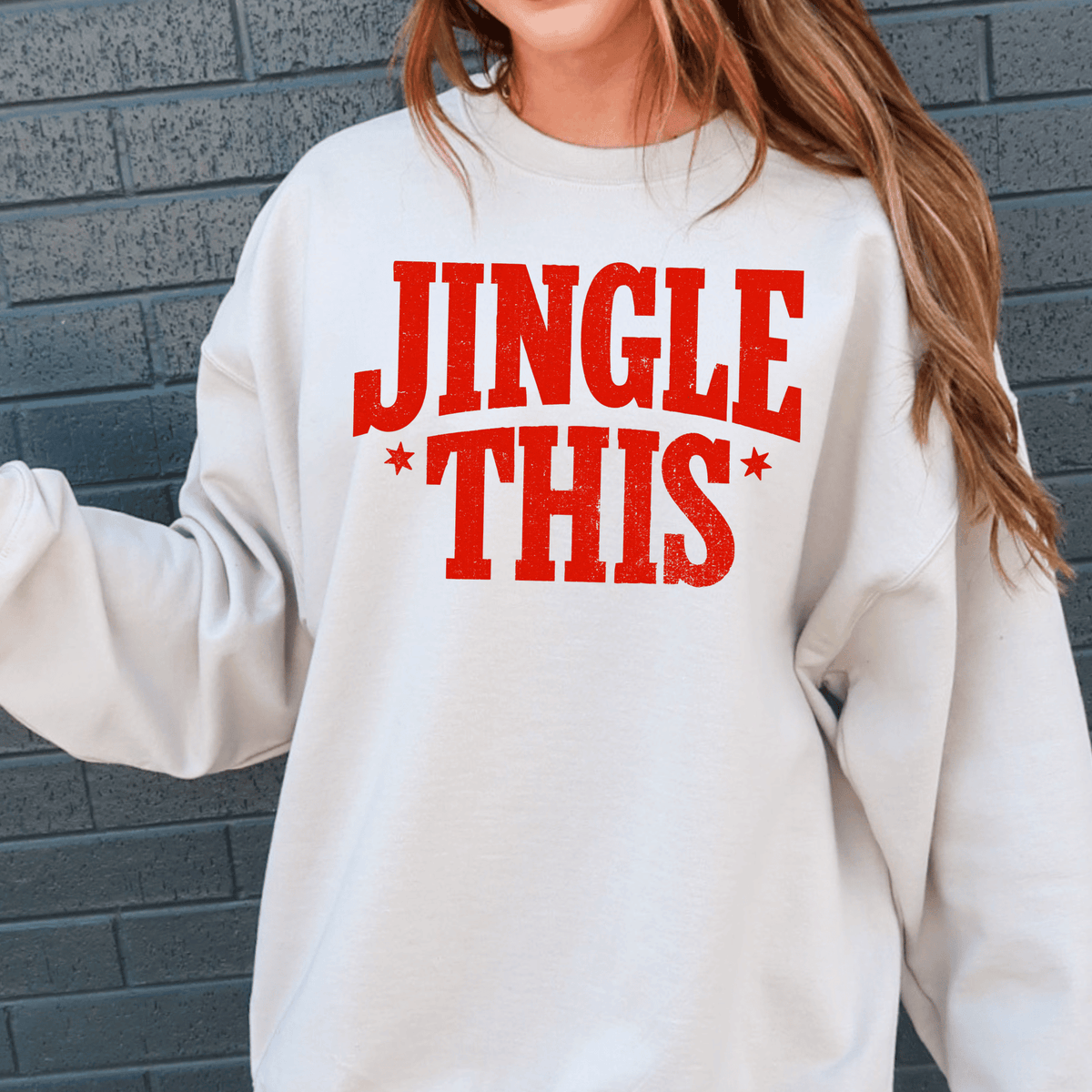 A person wearing a white sweatshirt with the text "JINGLE THIS" printed on it.