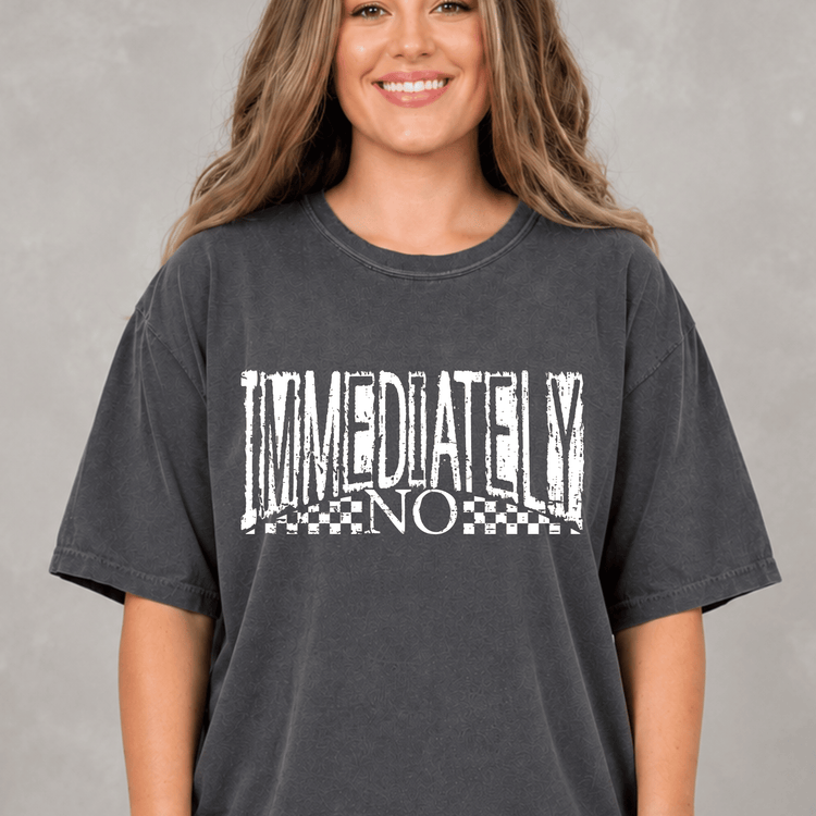 A woman wearing a gray t-shirt with the text "IMMEDIATELY NO" printed on it.
