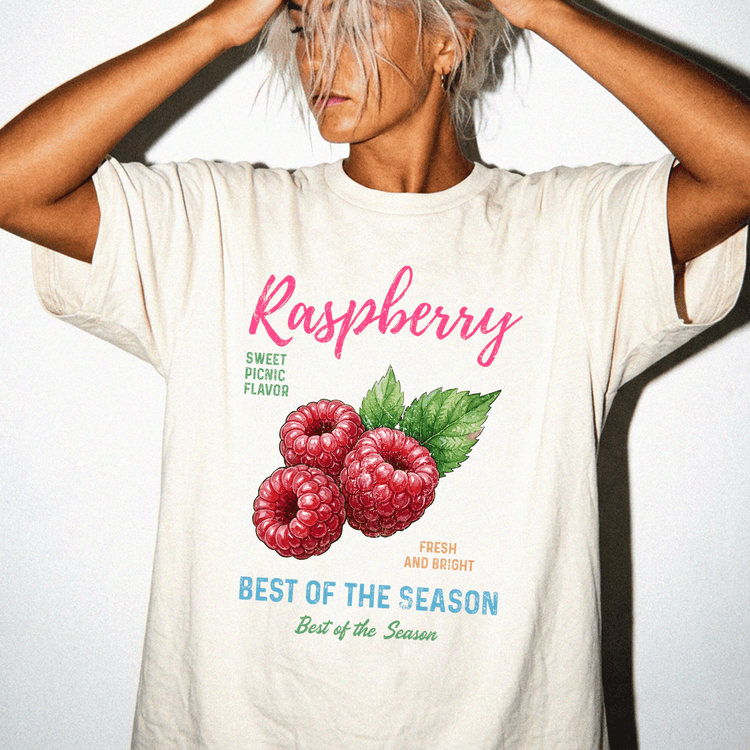 A person wearing a white t-shirt with a graphic of raspberries and text promoting raspberry flavor.