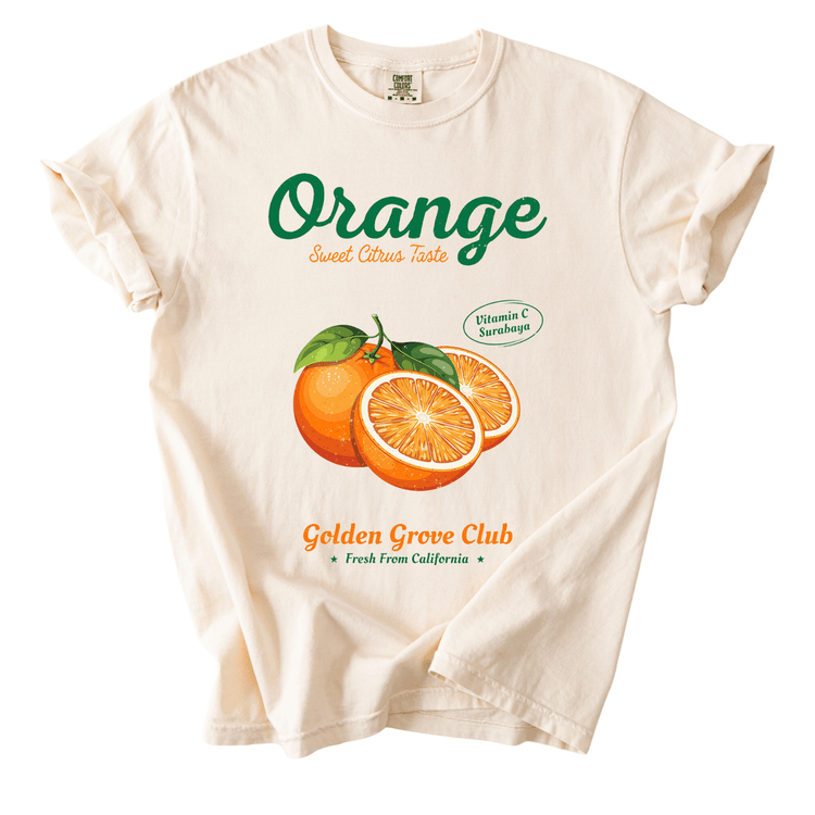 a white t-shirt with a graphic design of oranges and text that reads "Orange Sweet Citrus Taste" and "Vitamin C Surabaya" along with the text "Golden Grove Club" and "Fresh from California".