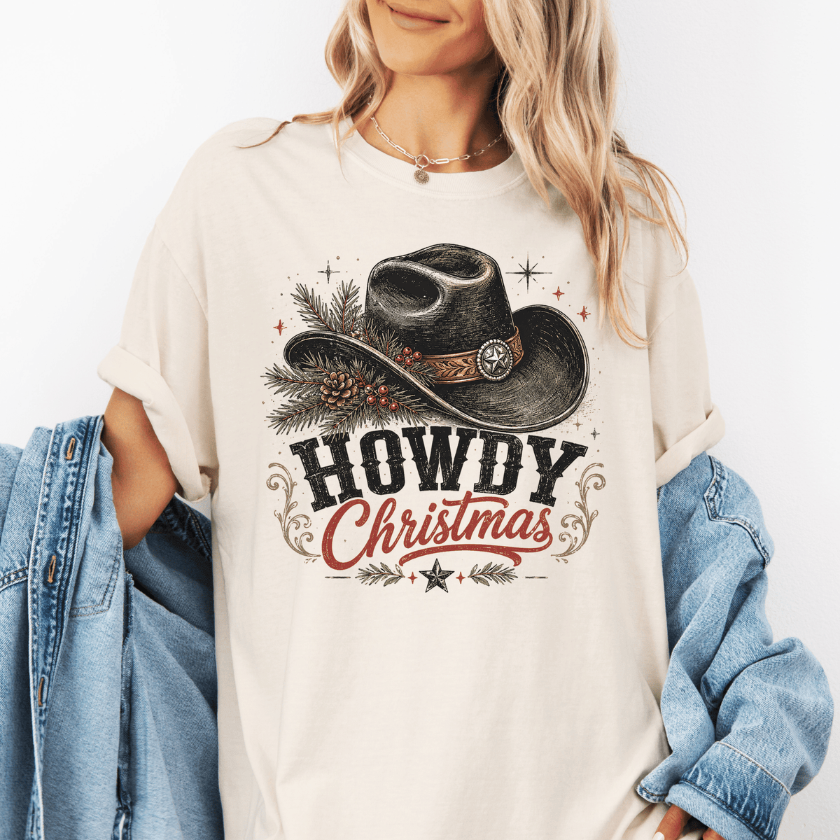 A woman wearing a white t-shirt with a graphic design of a cowboy hat and the text "HOWDY CHRISTMAS" printed on it.