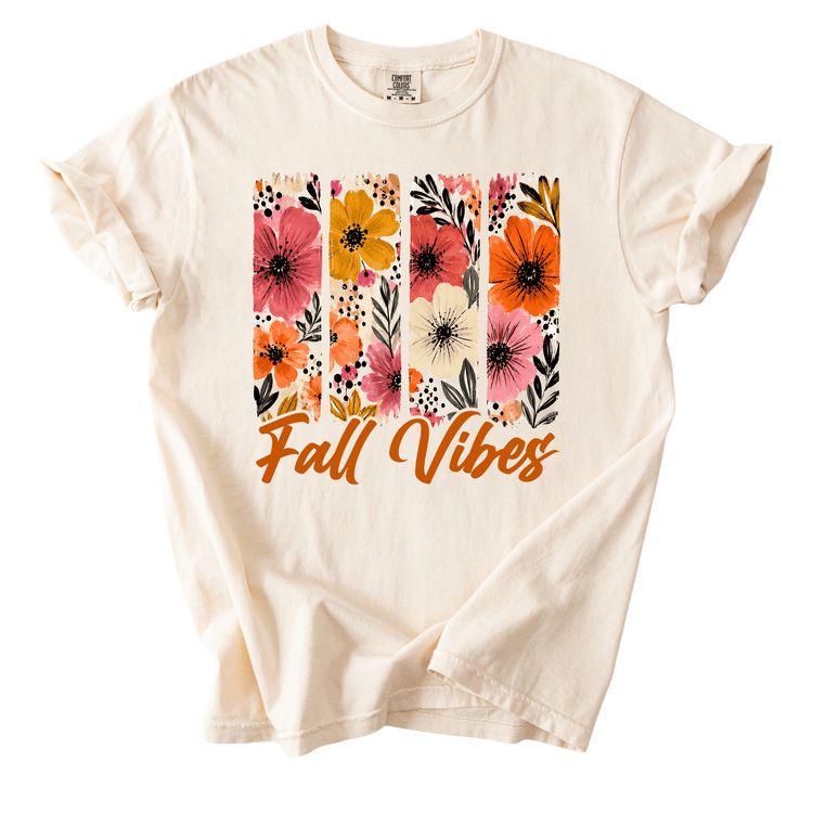 A white t-shirt with a floral design and the text "Fall Vibes" printed on it.