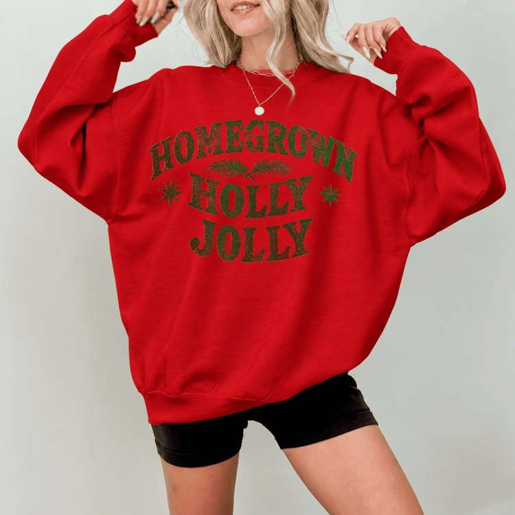 A woman wearing a red sweatshirt with the text "HOMEGrown Holly Jolly" printed on it.