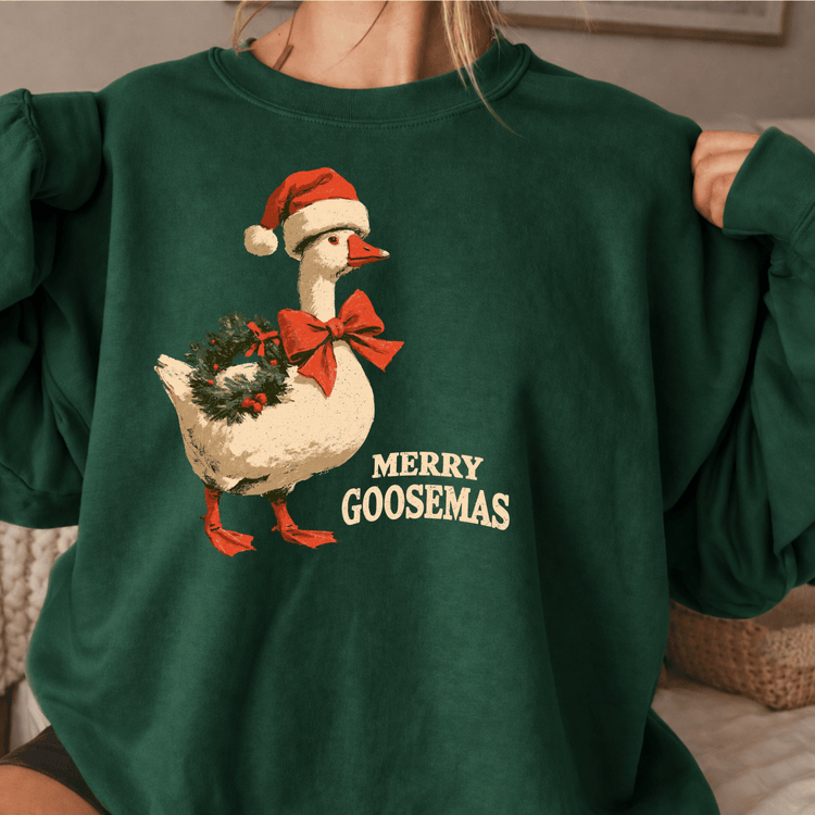 A green sweatshirt with a graphic of a goose wearing a Santa hat and a bow tie, along with the text "MERRY GOOSEMAS" printed on it.