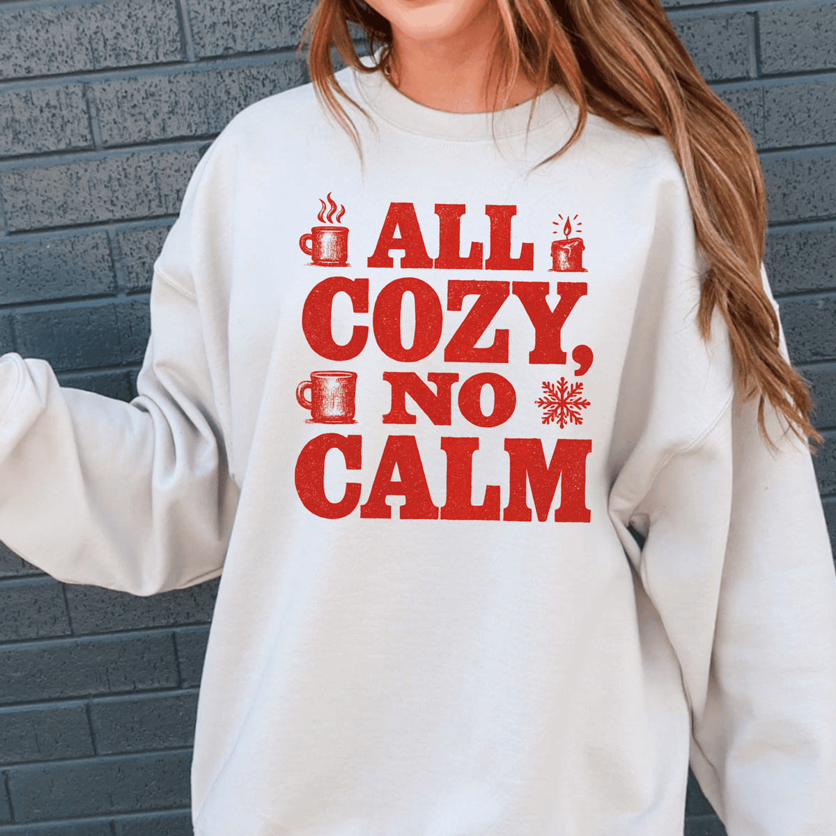 A white sweatshirt with a red text design that says "ALL COZY, NO CALM".