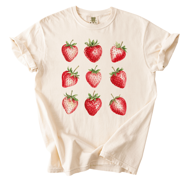 A white t-shirt with a graphic design of nine red strawberries arranged in a 3x3 grid.