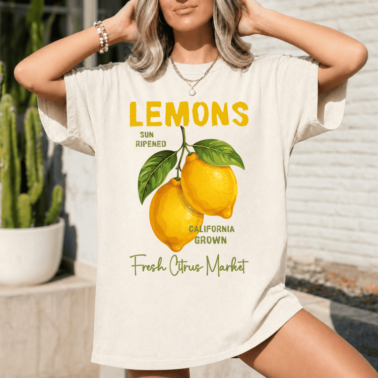 A woman wearing a white t-shirt with a graphic design of lemons and text related to the fresh citrus market.