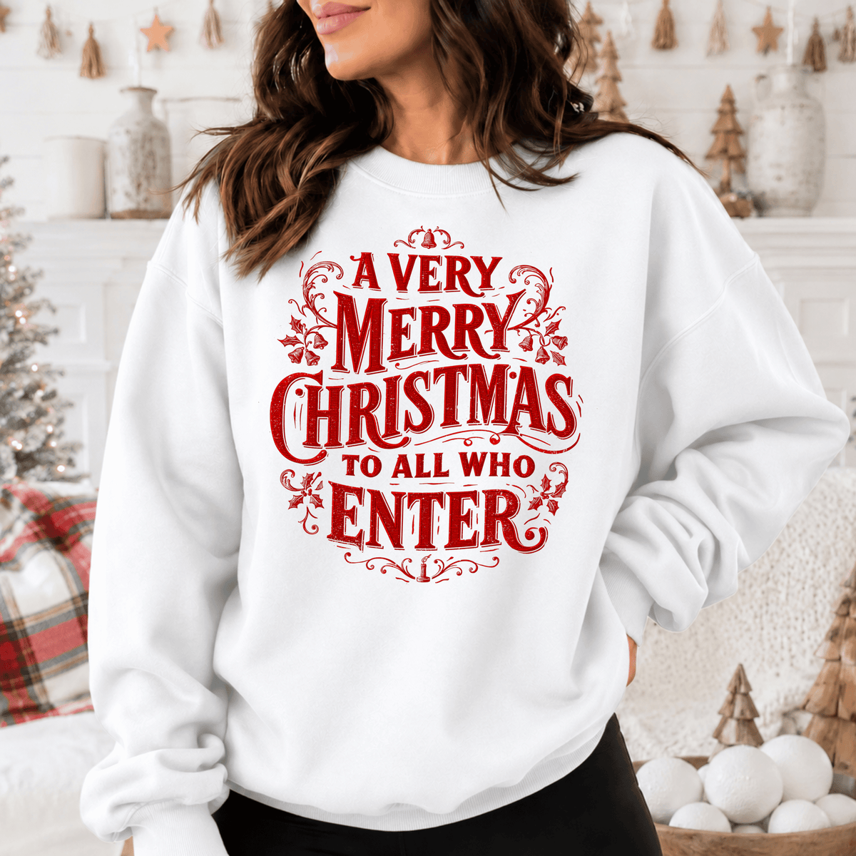 A woman wearing a white sweatshirt with a red and white text design that says "A very Merry Christmas to all who enter".