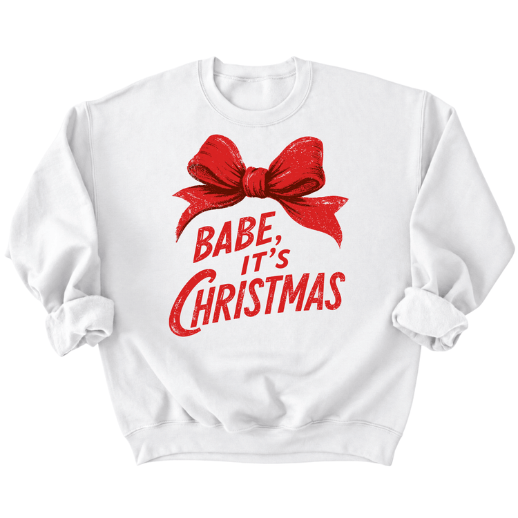A white sweatshirt with a red bow and the text "BABE, IT'S CHRISTMAS" printed on it.