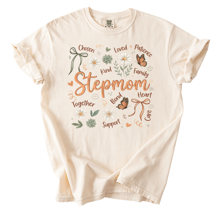 A white t-shirt with a floral and butterfly design, along with the text "Stepmom" and various words related to being a Stepmom, such as "Chosen", "Loved", "Patience", "Kind", "Family", "Together", "Support", "Love", and "Care".