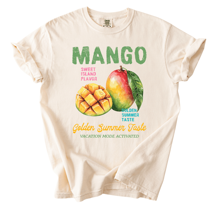 a white t-shirt with a graphic design depicting a mango and a slice of mango. The design includes text that reads "MANGO SWEET ISLAND FLAVOR" and "GOLDEN SUMMER TASTE VACATION MODE ACTIVATED".