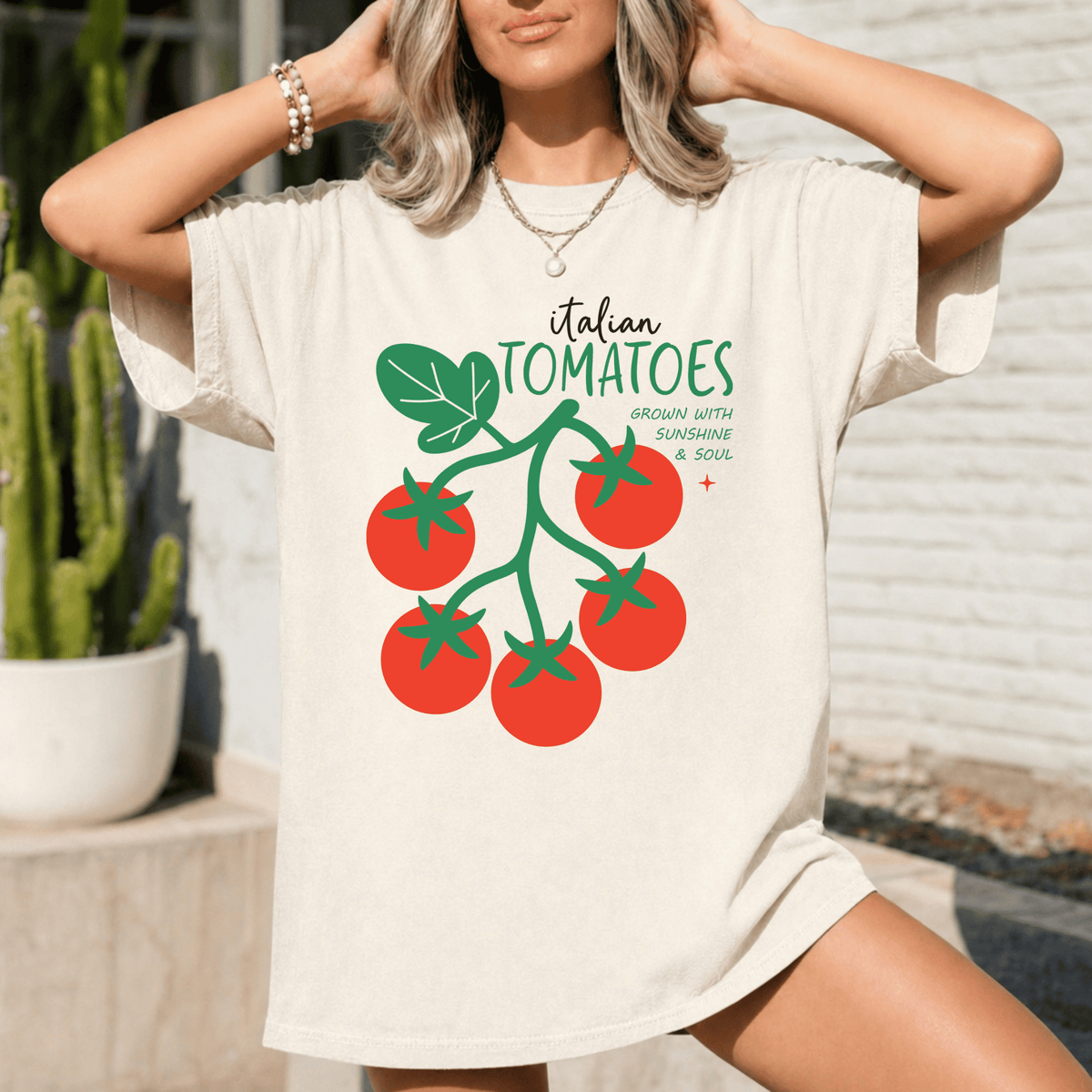 A woman wearing a white t-shirt with a graphic of tomatoes and the text "Italian Tomatoes" printed on it.