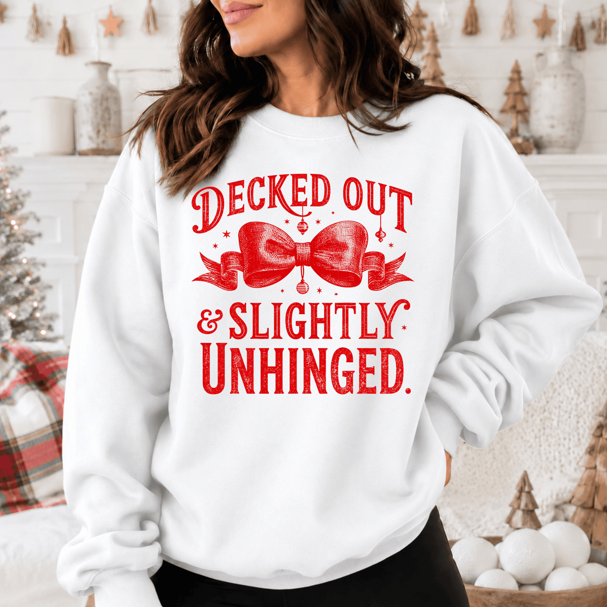 A woman wearing a white sweatshirt with a red bow and text printed on it.