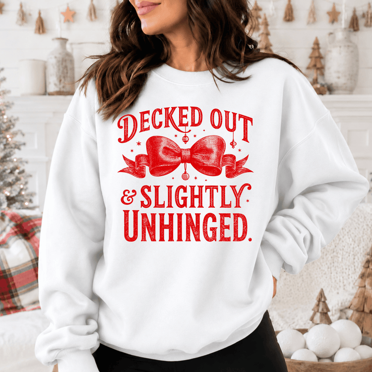 A woman wearing a white sweatshirt with a red bow and text printed on it.