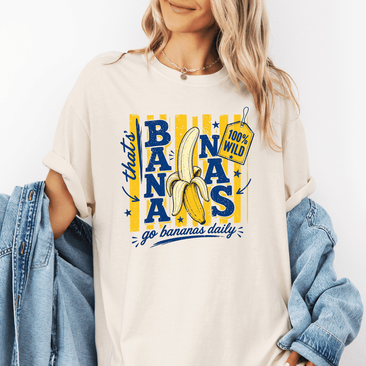 A woman wearing a white t-shirt with a graphic design of a banana and the text "go bananas daily" printed on it.