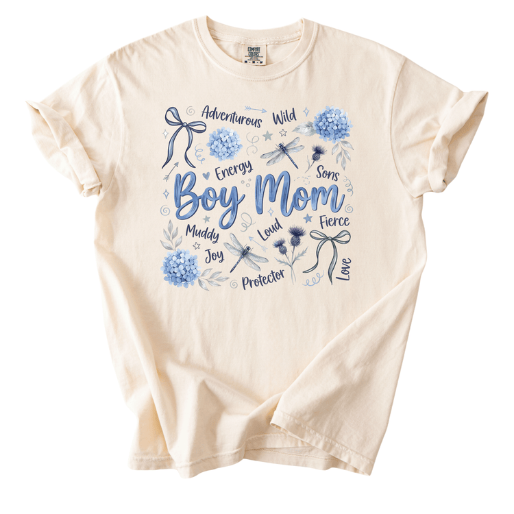 The image is a t-shirt with a graphic design featuring various words and illustrations related to a boy's mom.