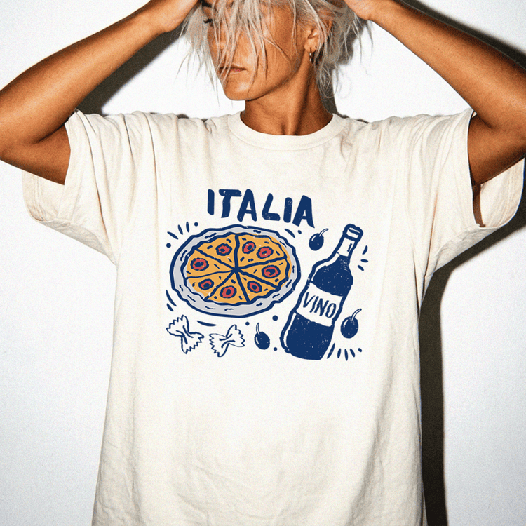 A person wearing a white t-shirt with a graphic design depicting a pizza and a bottle of wine.