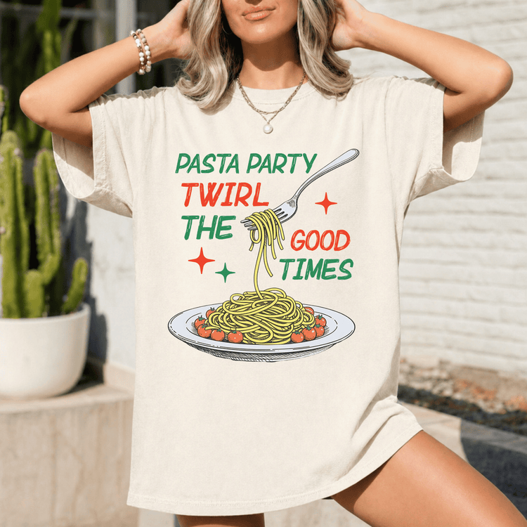 A woman wearing a white t-shirt with a graphic design of spaghetti and a fork, along with the text "Pasta Party Twirl The Good Times".