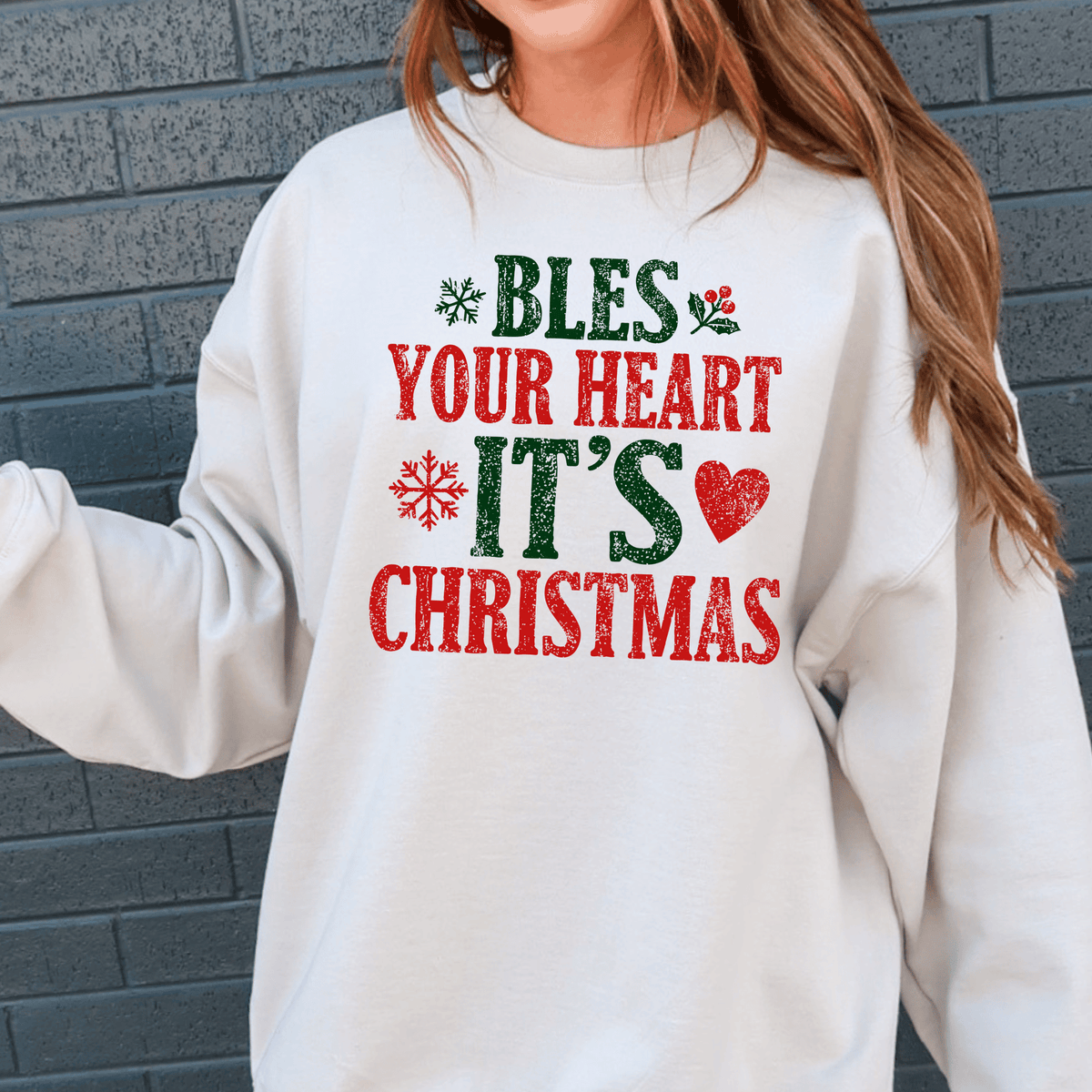 A white sweatshirt with a Christmas-themed design and text printed on it.
