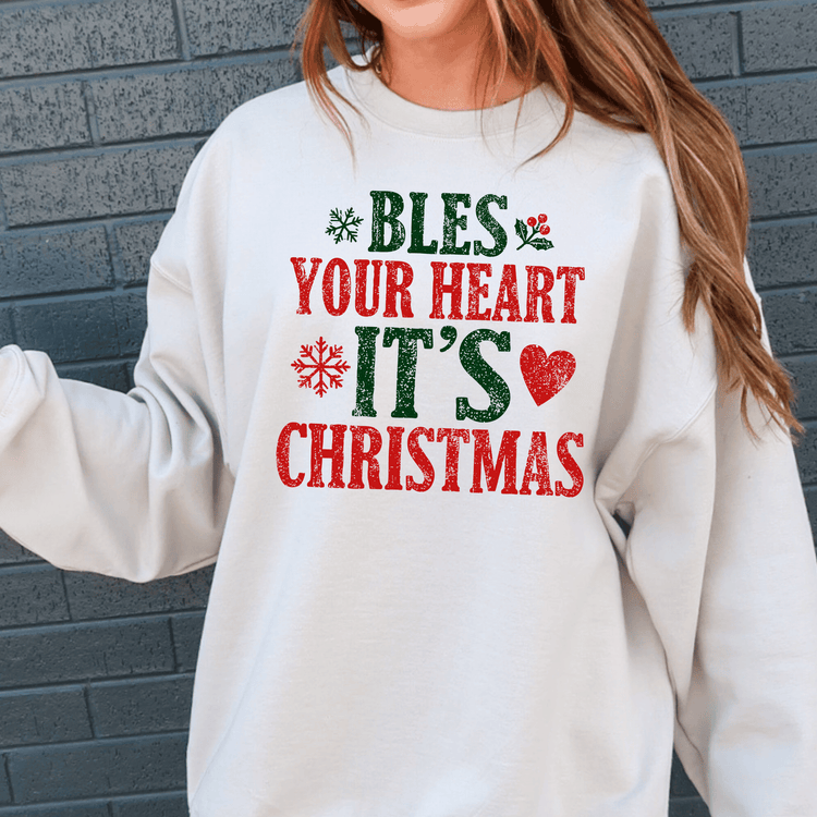 A white sweatshirt with a Christmas-themed design and text printed on it.