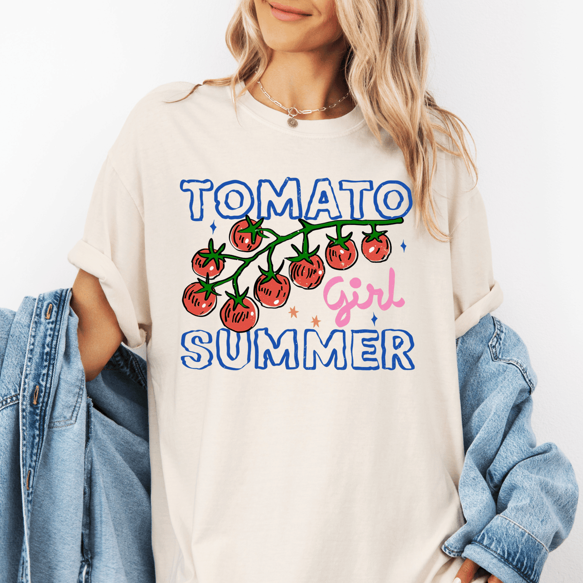 A woman wearing a white t-shirt with a graphic design of tomatoes and the text "TOMATO GIRL SUMMER" printed on it.