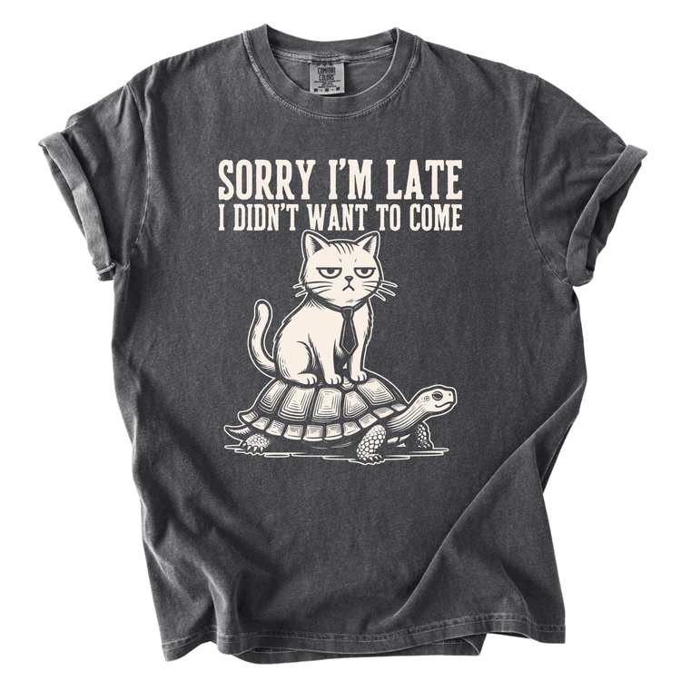 A gray t-shirt with a graphic design depicting a cat sitting on a turtle. The text above the image reads "Sorry I'm Late I Didn't Want to Come".