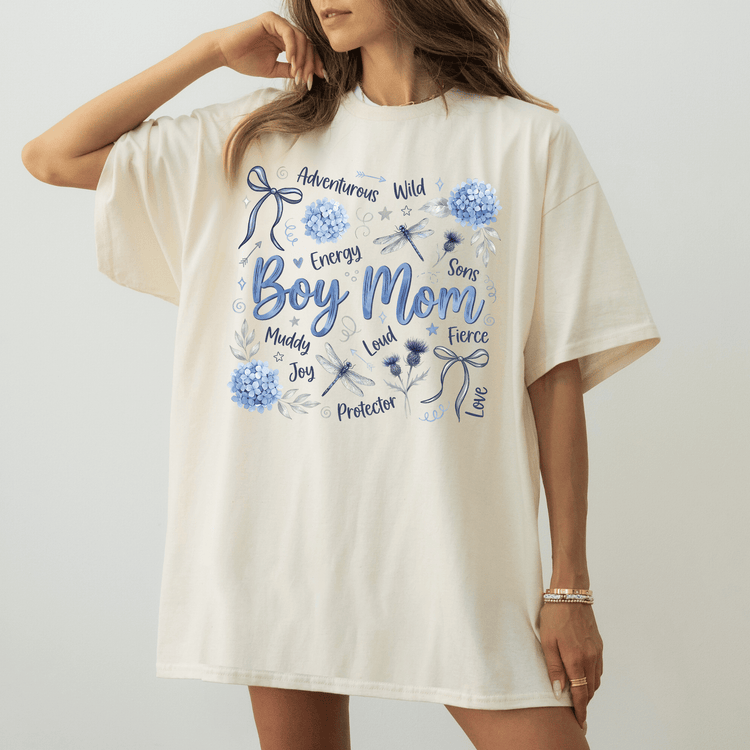 A woman wearing a white t-shirt with a graphic design featuring various words and illustrations related to a boy's mother.