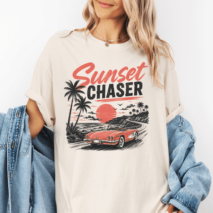 A woman wearing a white t-shirt with a graphic design of a red convertible car and palm trees, along with the text "Sunset Chaser".