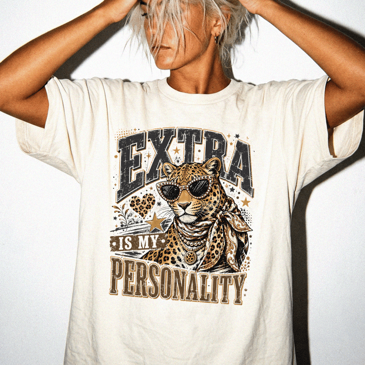 A person wearing a white t-shirt with a graphic design of a leopard and the text "EXTRA IS MY PERSONALITY" printed on it.