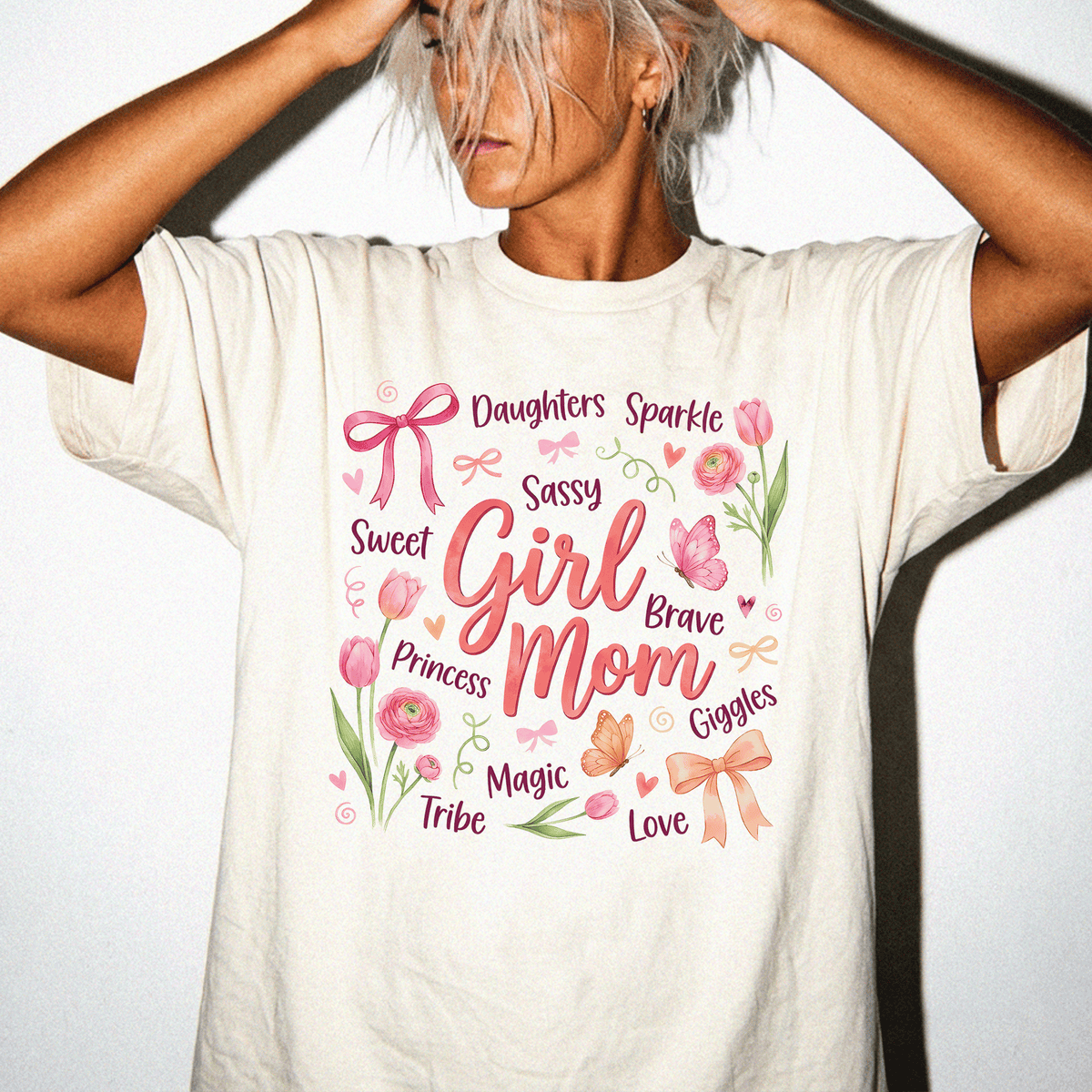 A woman wearing a white t-shirt with a graphic design featuring various words and illustrations related to a mother.