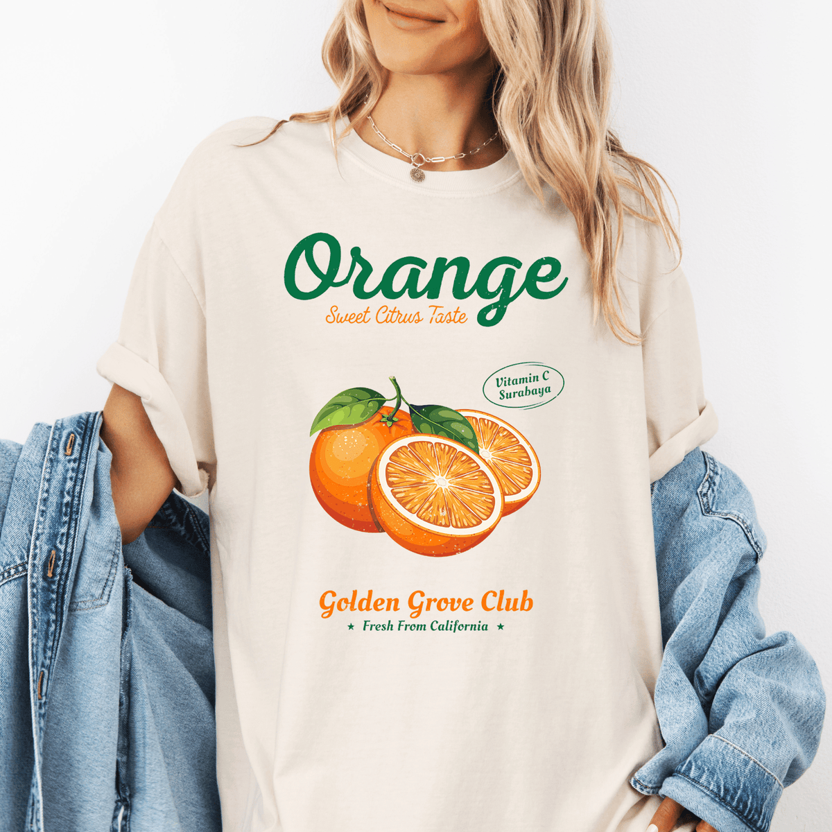A woman wearing a white t-shirt with an illustration of oranges and text promoting the "Orange" brand.