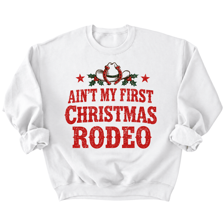A white sweatshirt with a red and white graphic design that says "Ain't my first Christmas rodeo" printed on it.