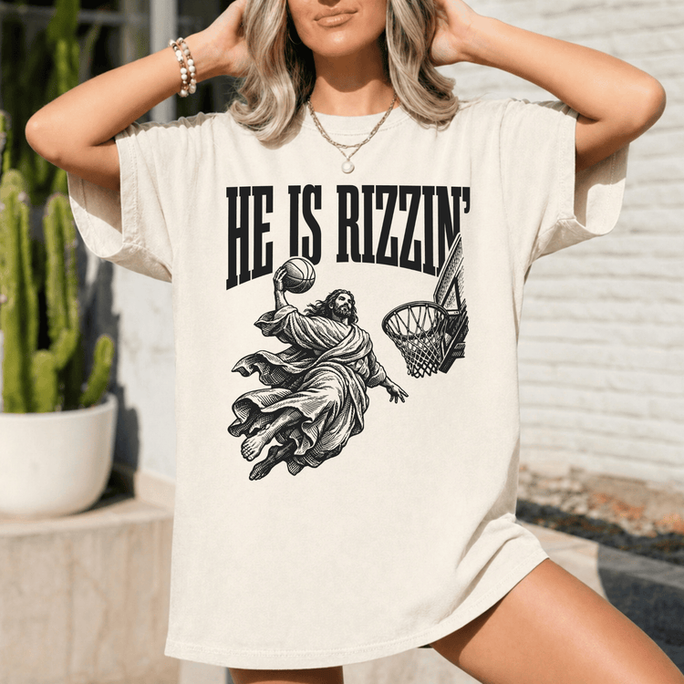 A woman wearing a white t-shirt with a graphic design depicting a basketball player in a religious pose.