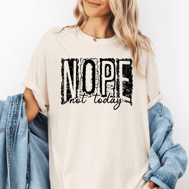 A woman wearing a white t-shirt with the text "NOPE not today" printed on it.