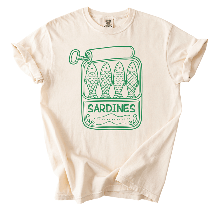 A white t-shirt with a graphic design depicting a can of sardines and the word "Sardines" printed on it.