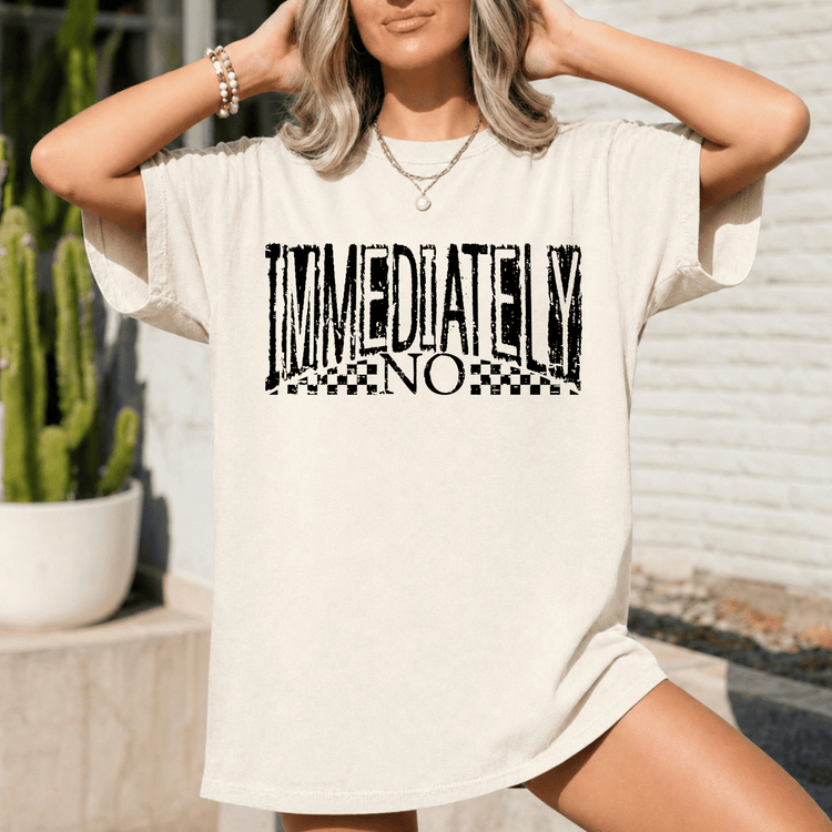 A woman wearing a white t-shirt with the text "IMMEDIATELY NO" printed on it.