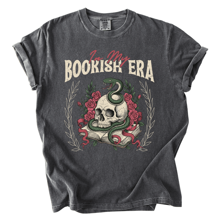 A gray t-shirt with a graphic design featuring a skull, a snake, and roses, along with the text "I'm my BOOKISH ERA" printed on it.