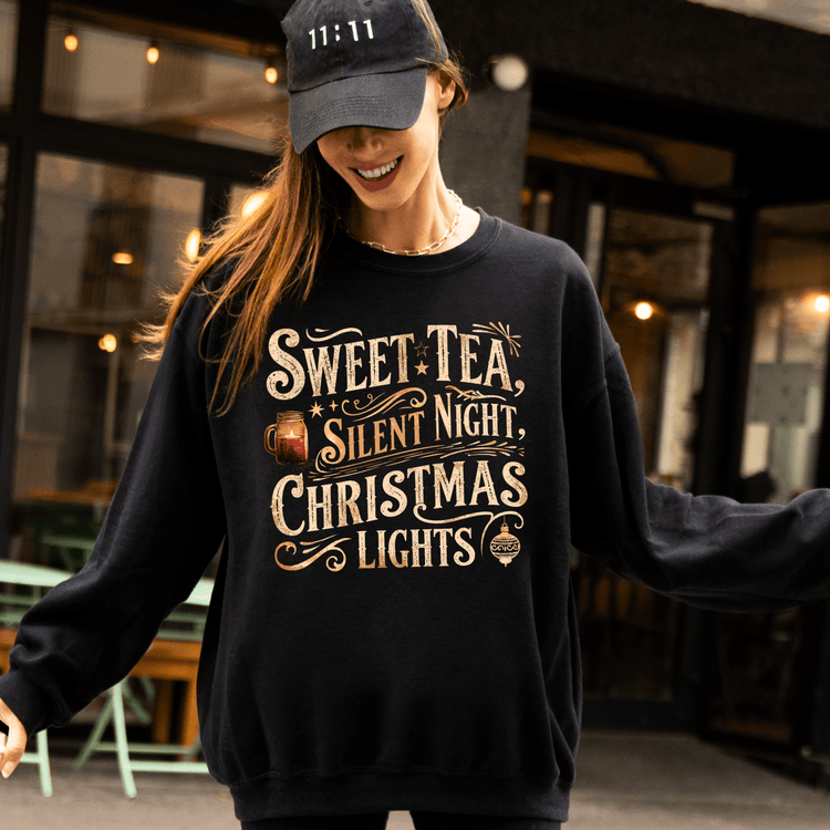 A woman wearing a black sweatshirt with a humorous Christmas-themed design, smiling and posing for the camera.