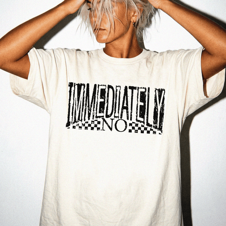 A person wearing a white t-shirt with the text "IMMEDIATELY NO" printed on it.