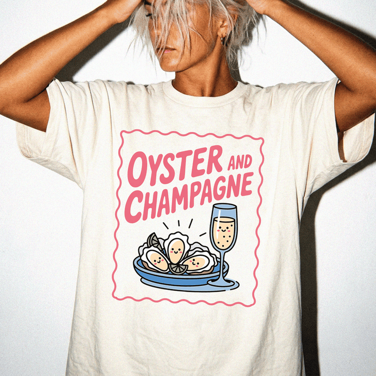 A person wearing a white t-shirt with a graphic design depicting a glass of champagne and oysters.