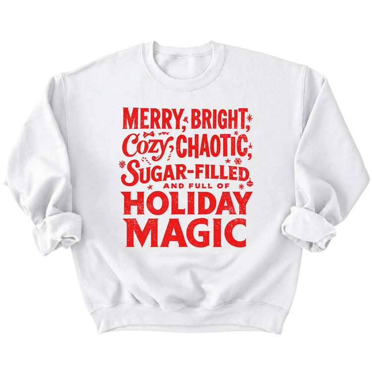 A white sweatshirt with a red text design that reads "MERRY, BRIGHT, COZY CHAOTIC, SUGAR-FILLED AND FULL OF HOLIDAY MAGIC".
