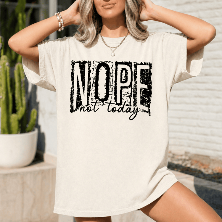 A woman wearing a white t-shirt with the text "NOPE not today" printed on it.