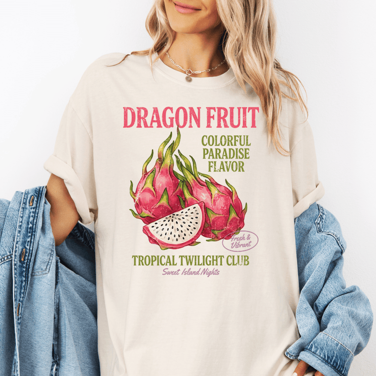 A woman wearing a white t-shirt with a graphic design featuring dragon fruit and text promoting a tropical fruit club.