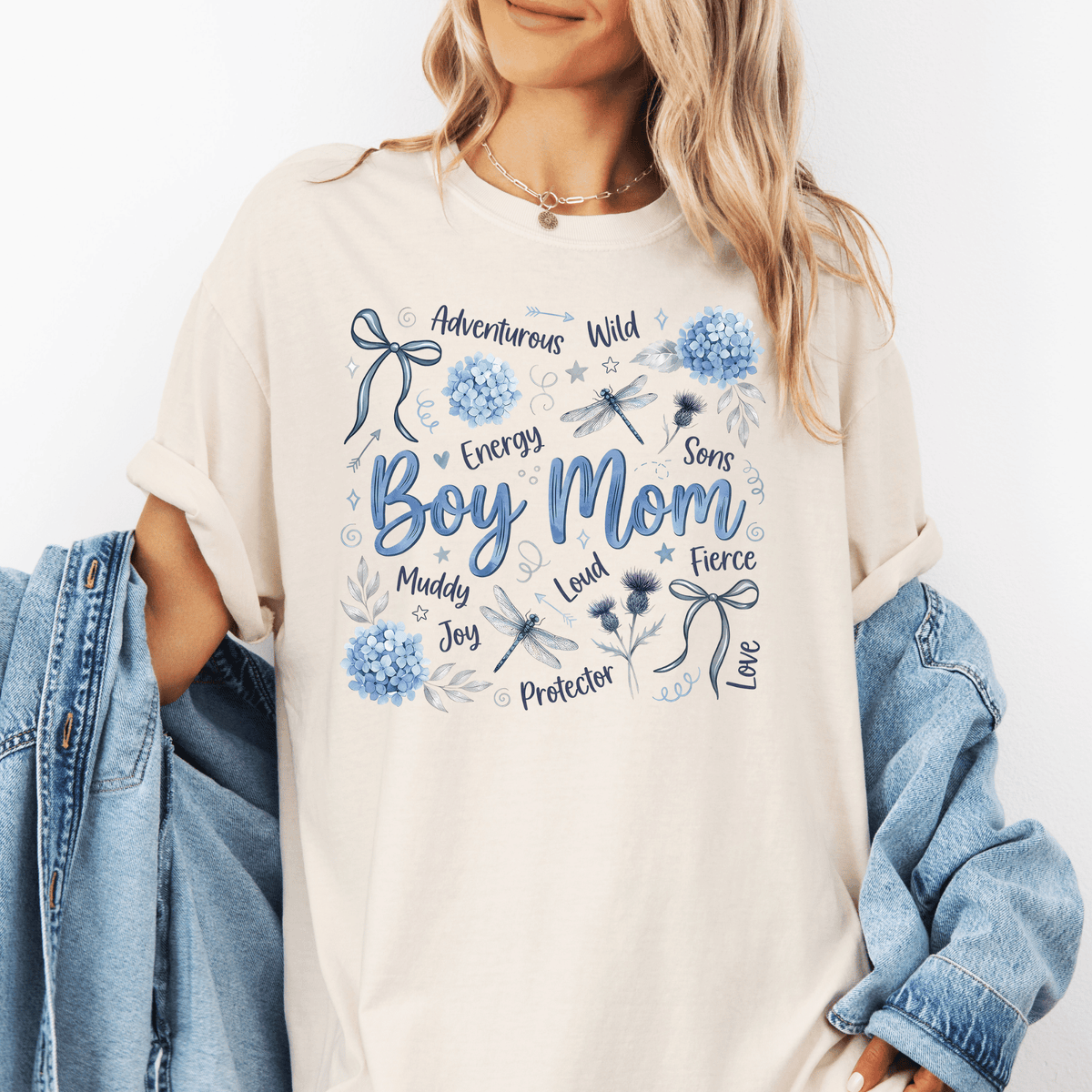 A woman wearing a white t-shirt with a graphic design featuring various words and illustrations related to a boy's mother.