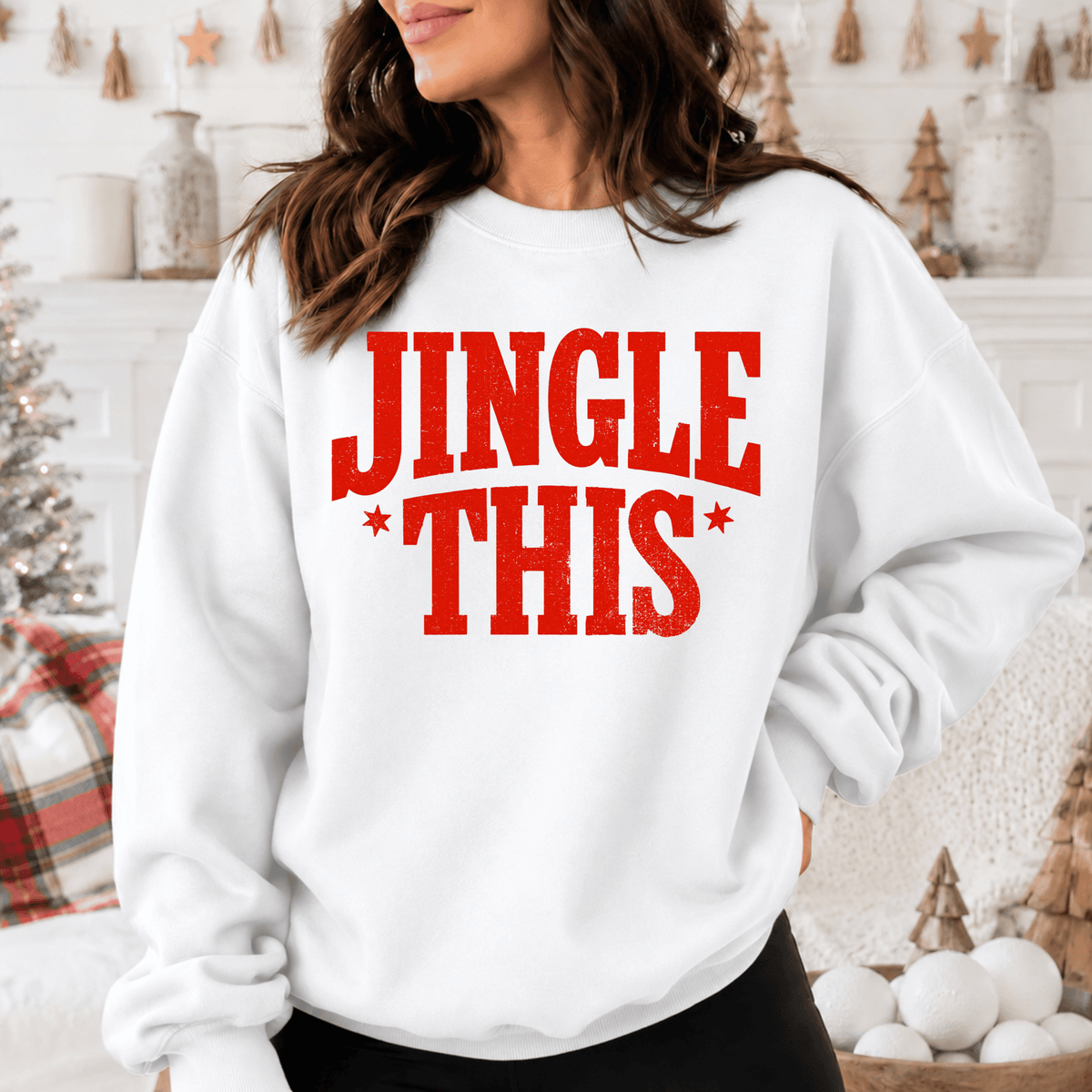A woman wearing a white sweatshirt with the text "JINGLE THIS" printed on it.