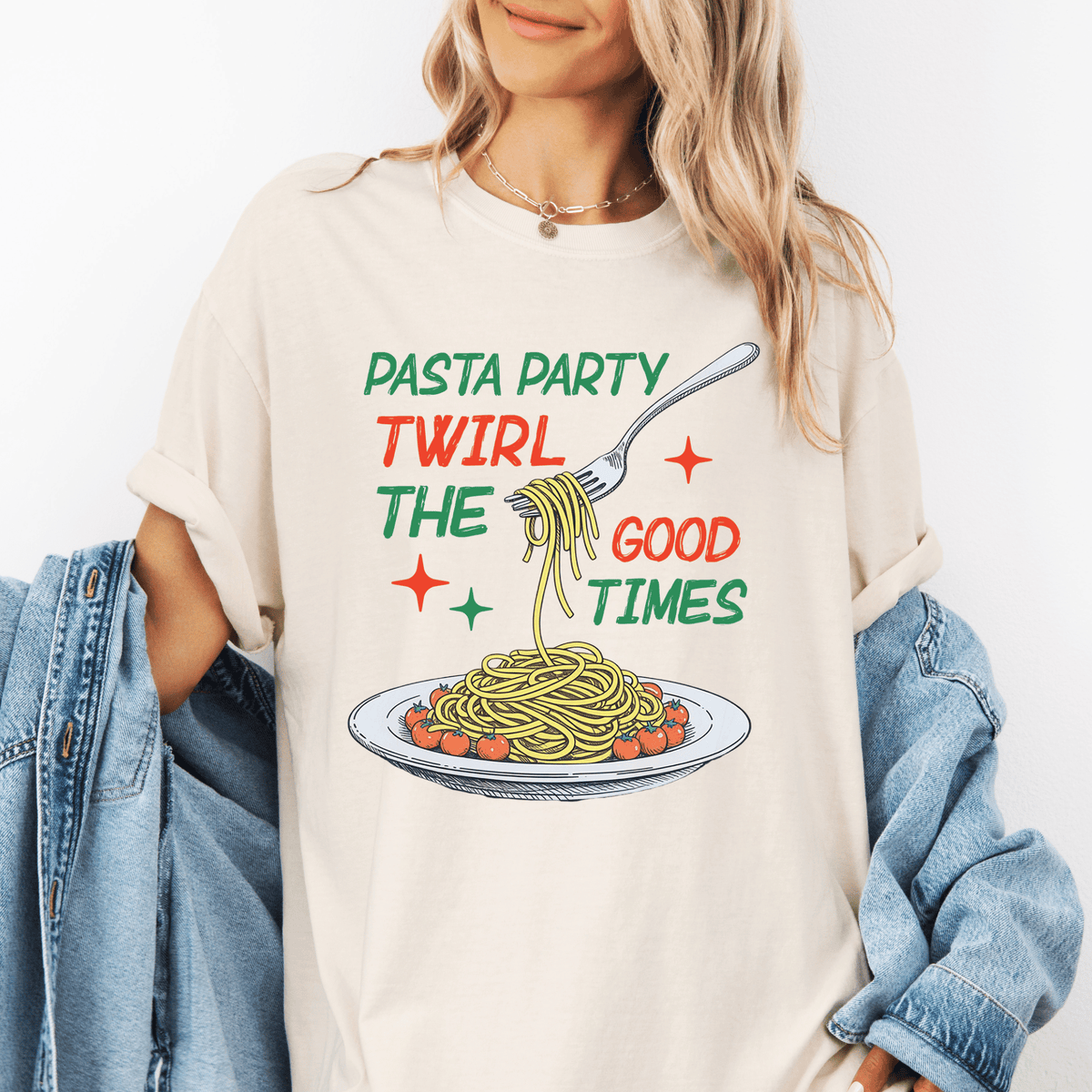A woman wearing a white t-shirt with a graphic design of spaghetti and a fork, along with the text "Pasta Party Twirl The Good Times".