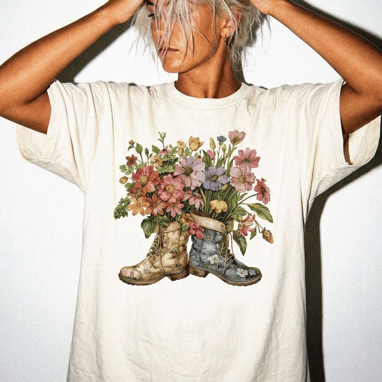 A woman wearing a white t-shirt with a colorful floral design of boots on the front.